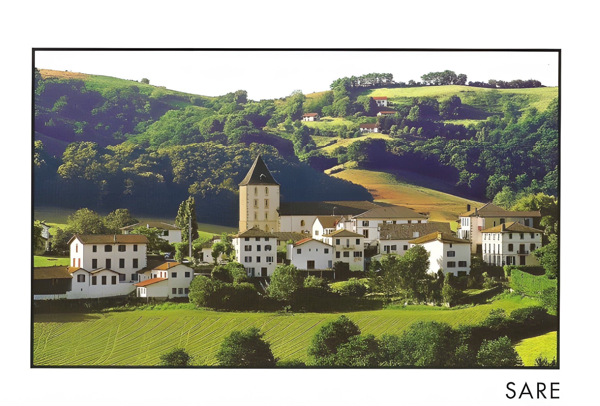Un pueblo con arquitectura tradicional, una iglesia destacada y un río al fondo.