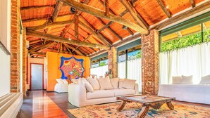A spacious room with a high wooden ceiling, a white sofa, a patterned rug, and a billiards table. - Cristal Apartments (Masserano)