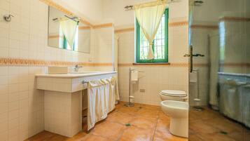 A bathroom with a sink, mirror, toilet, and shower.
