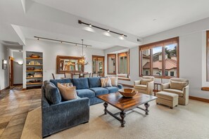 Ein geräumiges Wohnzimmer mit einem blauen Sofa, einem Holztisch und einem großen Spiegel.