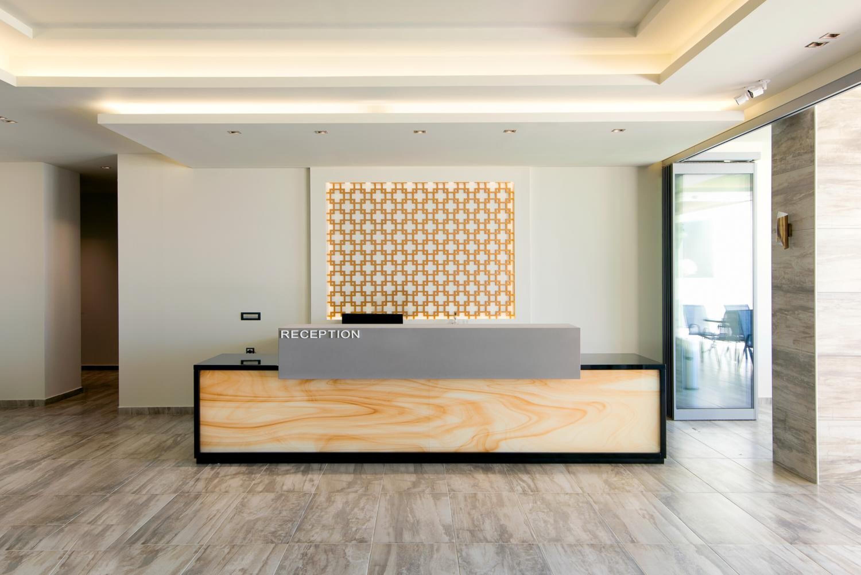 A reception desk with a marble-like design, a patterned wall decoration, and a modern interior.