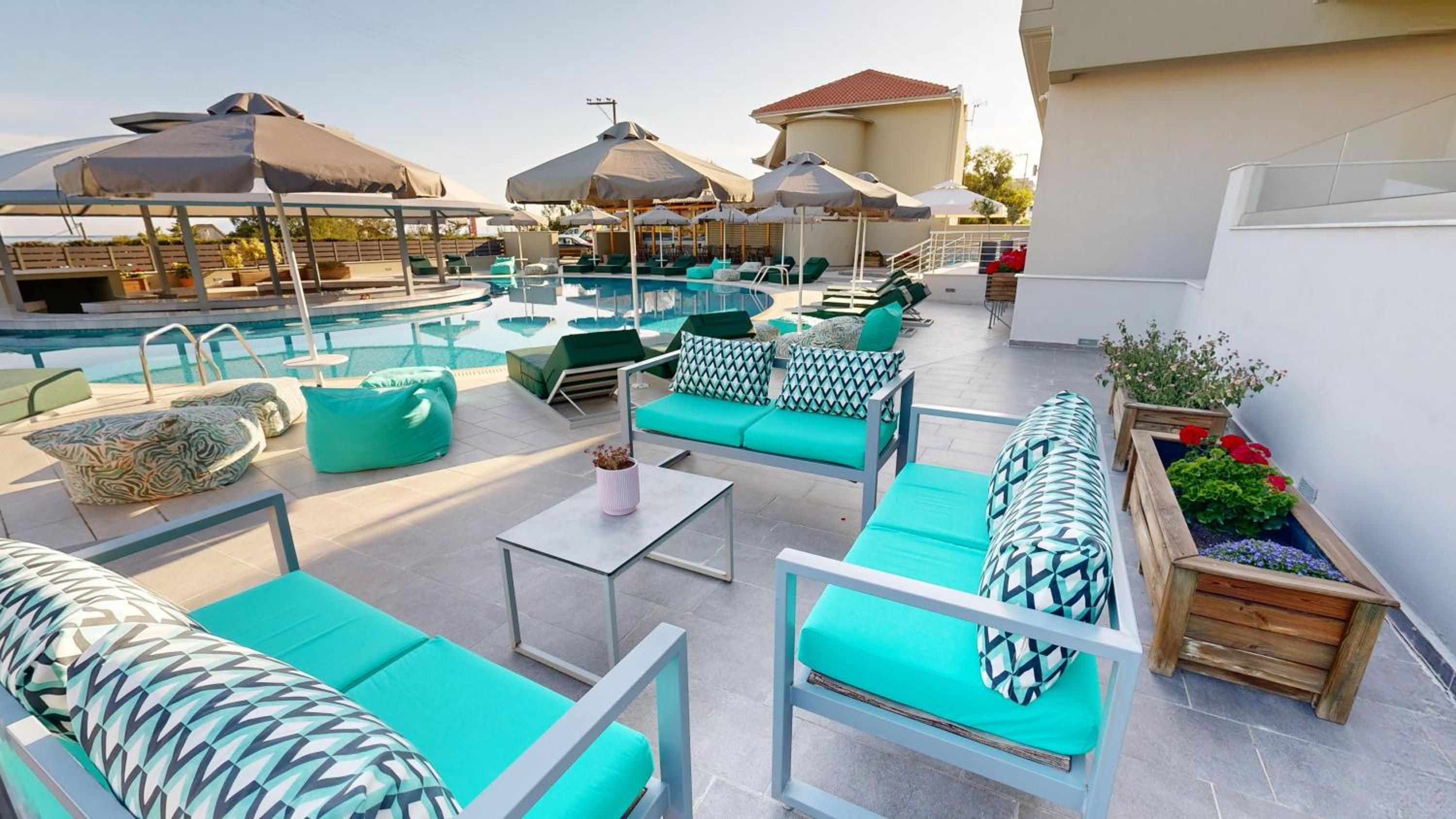 A rooftop pool area with lounge chairs and umbrellas.