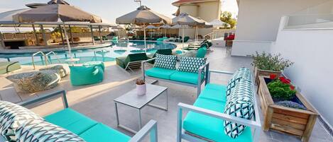 A rooftop pool area with lounge chairs and umbrellas.
