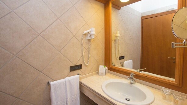 A bathroom with a sink, mirror, towel rack, and a telephone. - Hotel Centrale Sabaudia (Sabaudia)