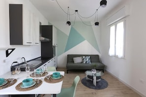 A compact living space with a kitchenette, dining area, and seating area. - Modern suite within walking distance of downtown (Molinella)