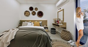 A modern bedroom with a bed, bedside table, wall art, and a large mirror. - Cretan Seaside Boutique Hotel (Hersonissos)
