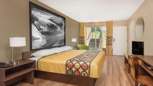 A hotel room with a large bed, a desk, a chair, a TV, and a window with curtains. - Asheville Airport Inn (Fletcher)