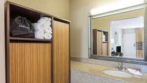 A hotel bathroom with a wooden vanity, a sink, and a mirror. - Asheville Airport Inn (Fletcher)