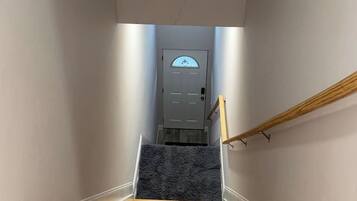 A wooden staircase leading to a door with a frosted glass window.