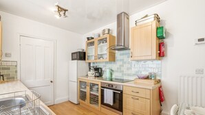 Cocina compacta con refrigerador, microondas, estufa y gabinetes.