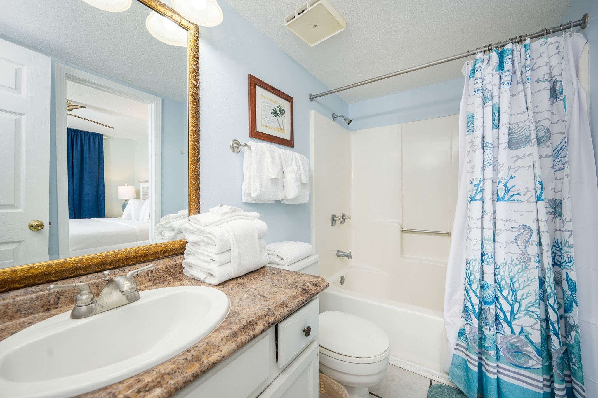 A bathroom with a sink, mirror, towel rack, and shower curtain.