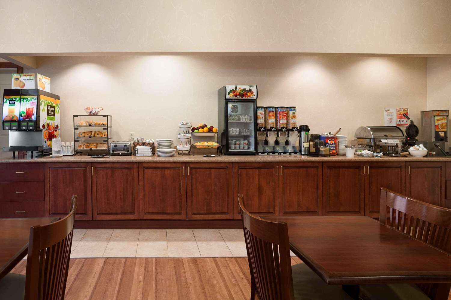 Un bar où l'on peut prendre le petit-déjeuner, avec des machines à café, un présentoir de fruits et un espace buffet.