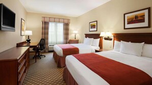 A hotel room with two beds, a desk, a chair, and a television. - Country Inn & Suites by Radisson, Manchester Airport, NH (Bedford)