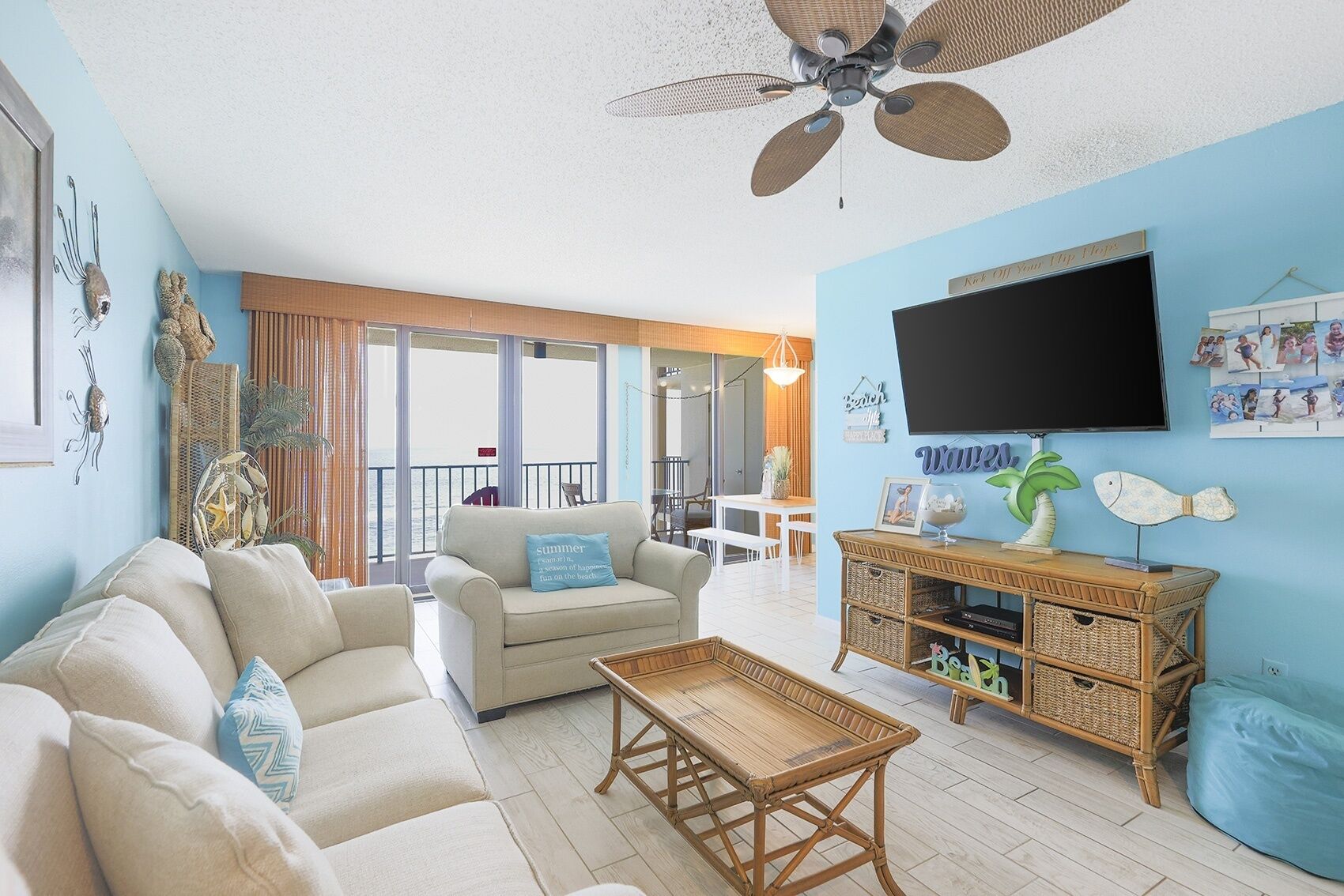 A living room with a sofa, a coffee table, a TV, and a balcony with a view.
