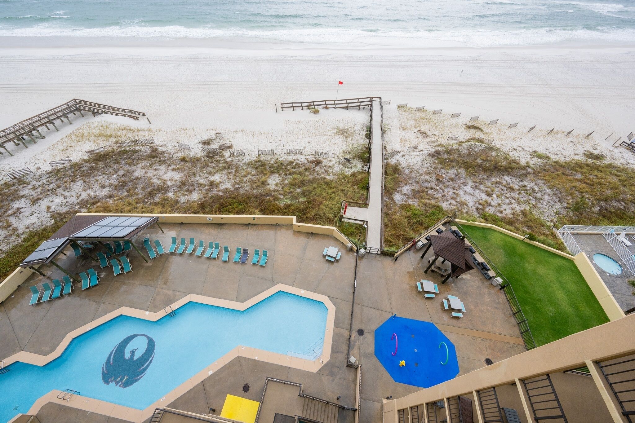 Een hotel aan het strand met een zwembad, toegang tot het strand en uitzicht op de oceaan.