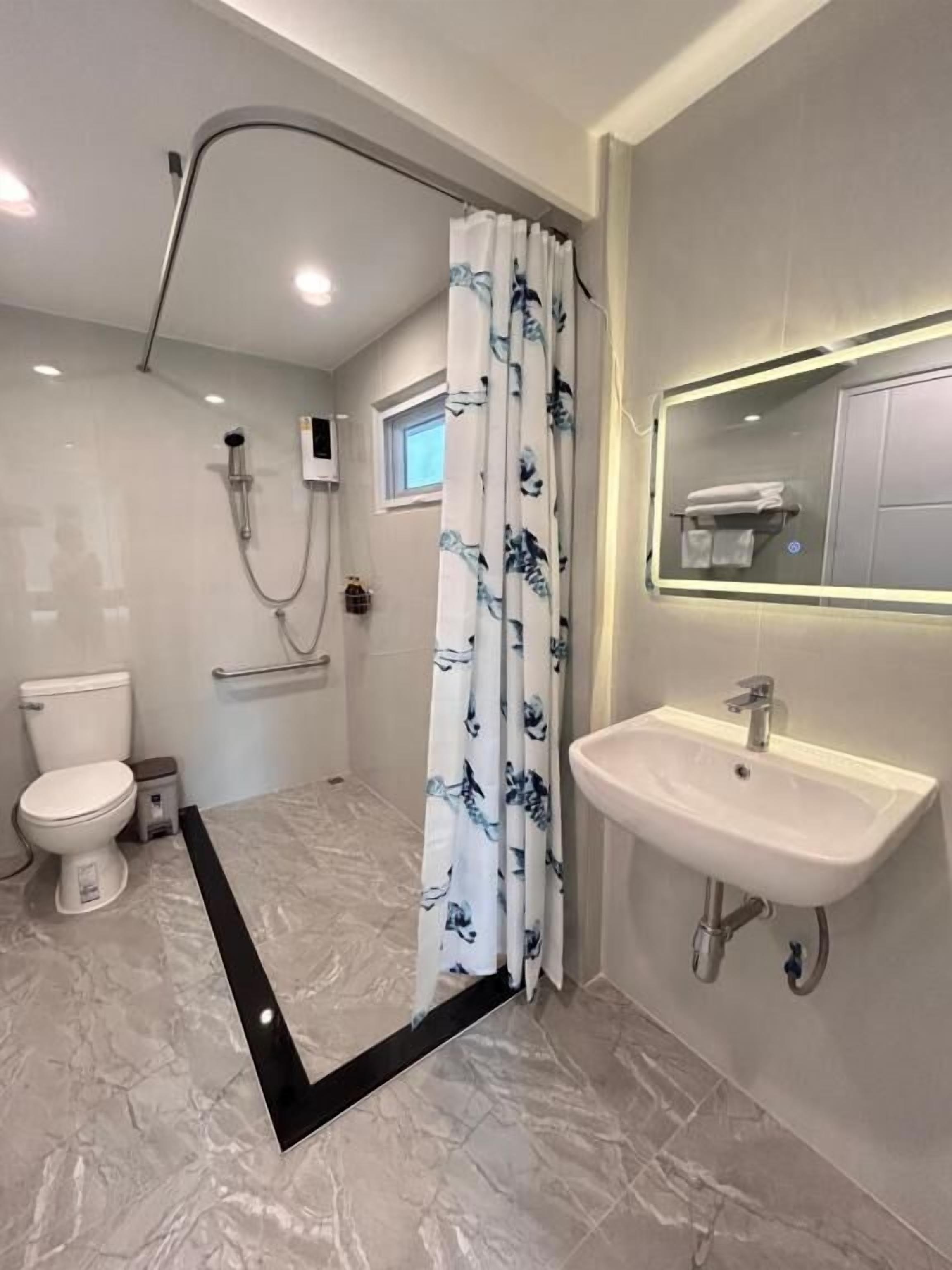 A modern bathroom with a shower, toilet, and sink.