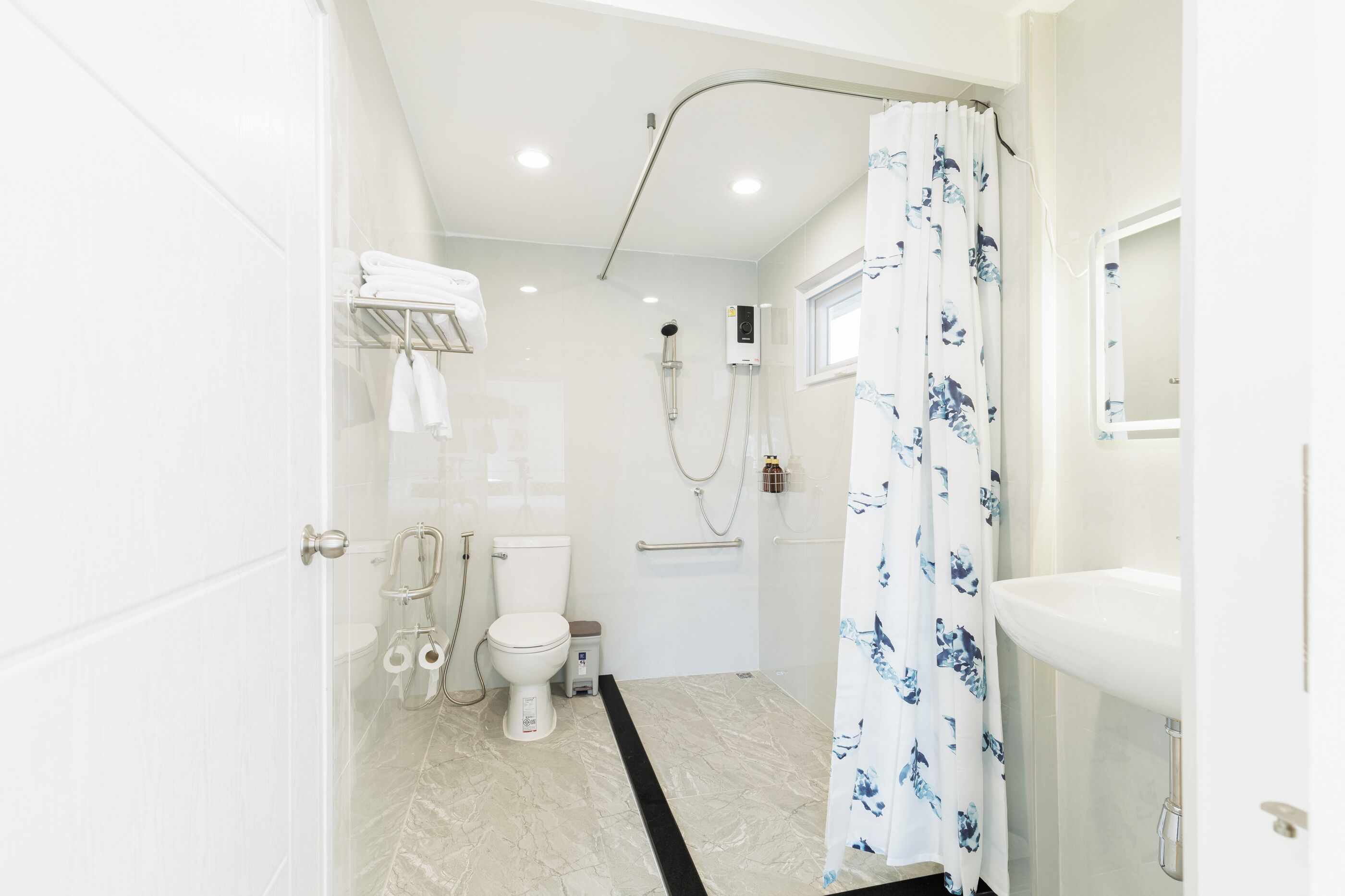 A modern bathroom with a toilet, shower, and sink.
