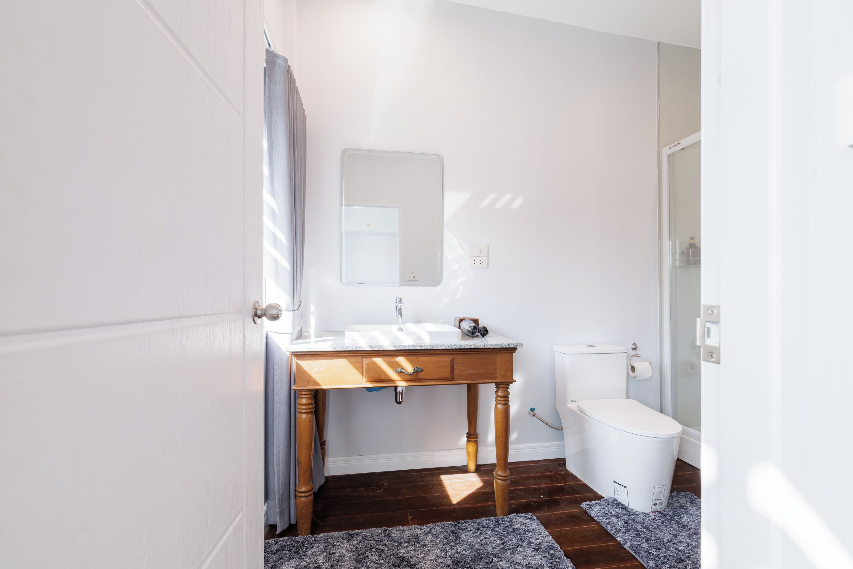 Un bagno con mobile lavabo in legno, lavandino bianco e water.