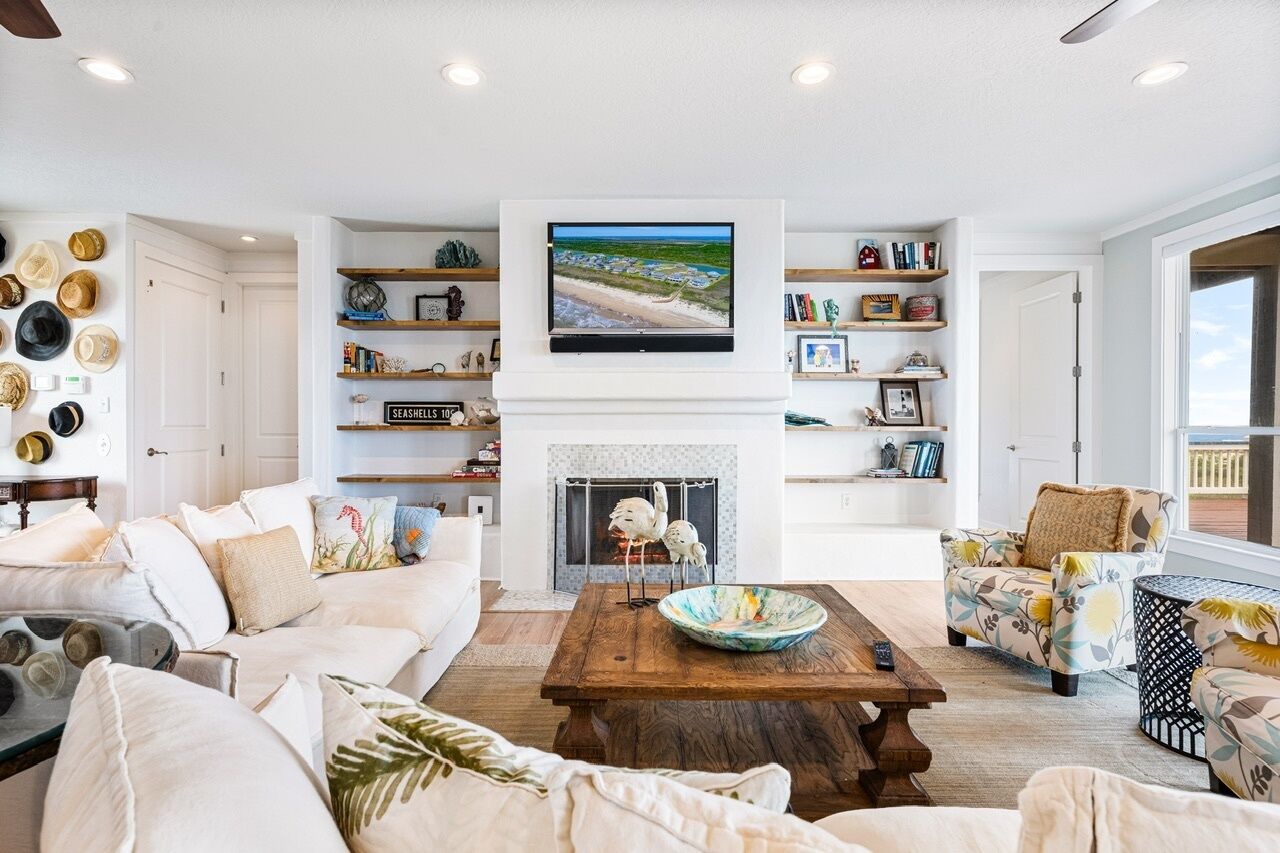 A living room with a fireplace, a television, and a bookshelf.