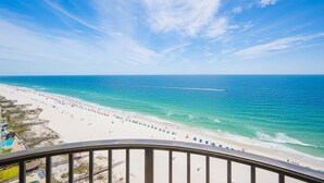 A beach view with a clear sky, a sandy shore, and a long pier extending into the water. - Phoenix West 1803 3 Bedroom Condo (Orange Beach)
