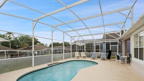 A covered swimming pool with lounge chairs and a greenhouse structure. - Bkd835 4 Bedroom Home (Davenport)
