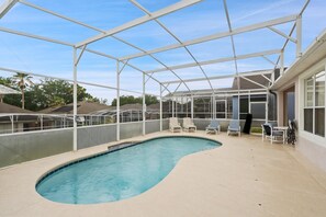 A covered swimming pool with lounge chairs and a greenhouse structure. - Bkd835 4 Bedroom Home (Davenport)
