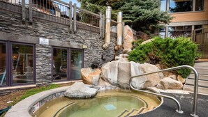 A stone building with a pool, metal railings, and a sign prohibiting smoking. - Aw K17 2 Bedroom Condo (Snowmass Village)