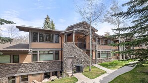 A modern building with a stone facade, large windows, and a covered outdoor area. - Aw K17 2 Bedroom Condo (Snowmass Village)