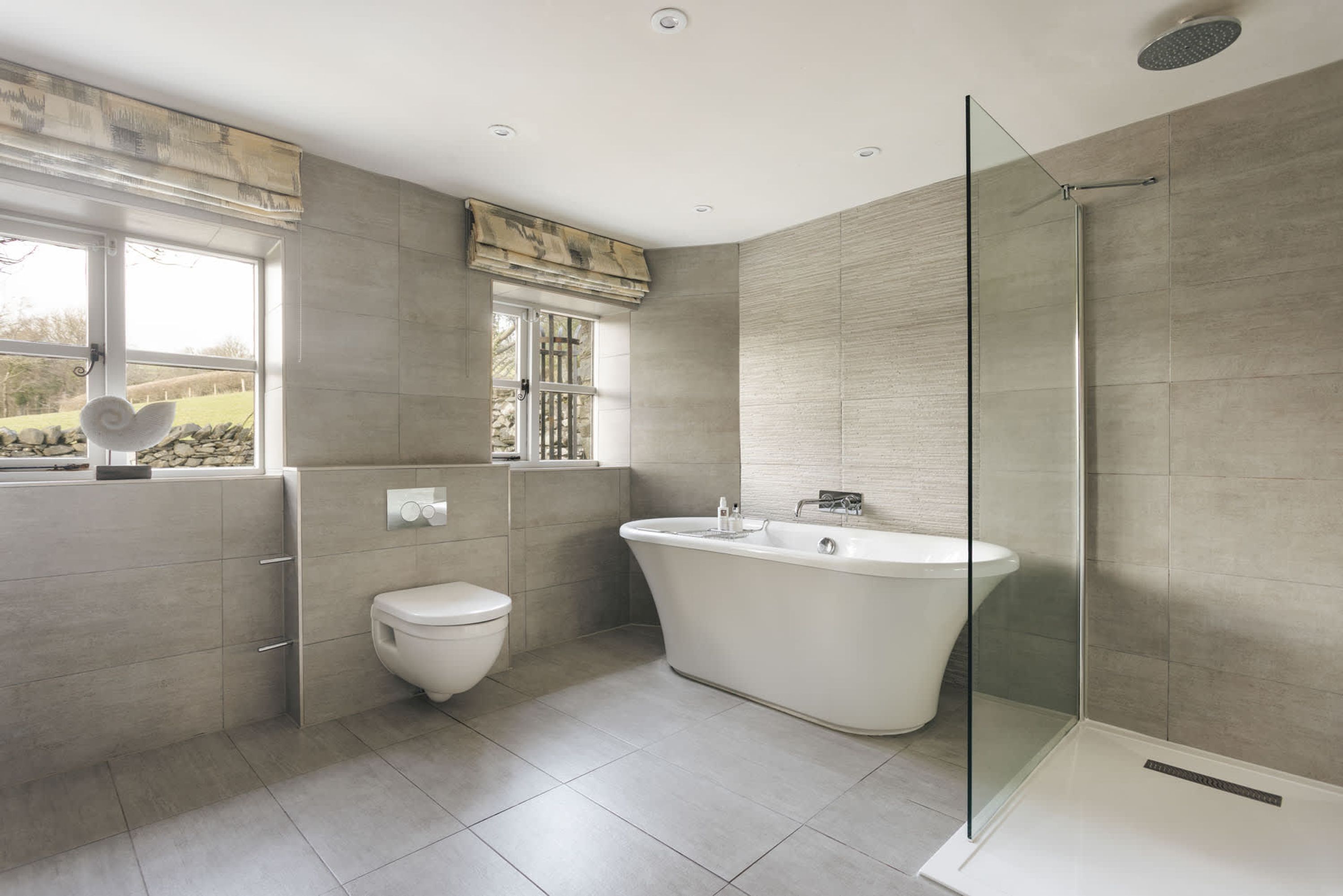 A modern bathroom with a freestanding bathtub, a glass-enclosed shower, and a toilet.