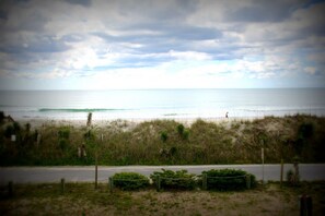 A beach with a fence, a road, and a person walking. - Your Coastal Retreat Awaits at Giddy's Get Away (N Topsail Beach)