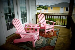 A porch with two pink Adirondack chairs and a floral rug. - Your Coastal Retreat Awaits at Giddy's Get Away (N Topsail Beach)