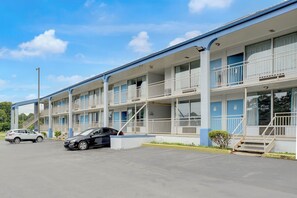 A motel with multiple floors, balconies, and a parking lot. - Ole South Inn Jackson I 40 TN (Denmark)