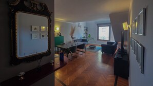 A spacious living area with a large mirror, a dining table, and a seating area. - Stylish & Cozy Apartment in the Center (Firenze)