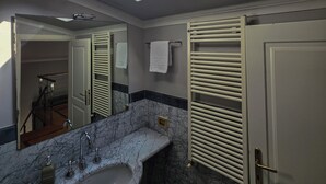 A bathroom with a skylight, a sink, a mirror, and a door. - Stylish & Cozy Apartment in the Center (Firenze)