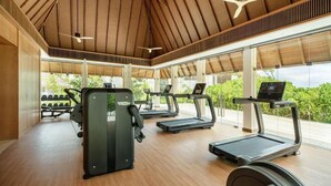 Uma academia com esteiras, bicicleta ergométrica e aparelho de musculação.
