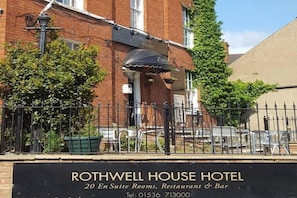 Um hotel chamado 'Rothwell House Hotel' com uma placa indicando 20 quartos privativos, um restaurante e um bar.