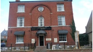 A red brick building with a sign for 'Rothwell Hotel Restaurant' and a 'Lunch From £4.95' sign. - OYO Rothwell House Hotel (Kettering)