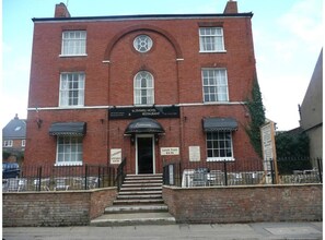 Um edifício de tijolos vermelhos com uma placa indicando 'Rothwell Hotel Restaurant' e uma placa com a mensagem 'Almoço a partir de £4,95'.
