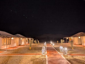A row of tents with a central pathway, each tent has a small tree in front. - Luxury Desert Camp Merzouga - AC, Private Bathroom & Breakfast (Merzouga)
