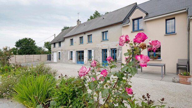 A two-story building with a stone facade and blue-framed windows. - Bed and Breakfast 'Chambre Chausey' with Shared Terrace, Shared Garden and Wi-Fi (Muneville-sur-Mer)