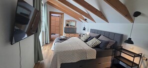 Un dormitorio con cama, mesita de noche, lámpara y espejo.