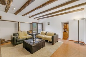 A living room with two sofas, a coffee table, and exposed wooden beams on the ceiling. - Casa Eyrie Centovalli 3BR Chalet (Centovalli)
