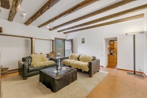 A living room with two leather sofas, a coffee table, and a fireplace.