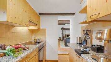 Una cocina con armarios de madera, encimera de granito y cafetera.