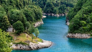 A serene river surrounded by dense forest, with a small building on the left bank. - Casa Eyrie Centovalli 3BR Chalet (Centovalli)