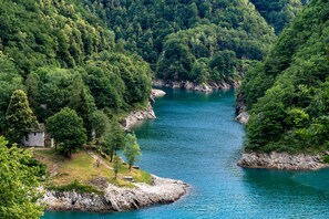 A serene river surrounded by dense forest, with a small building on the left bank. - Casa Eyrie Centovalli 3BR Chalet (Centovalli)