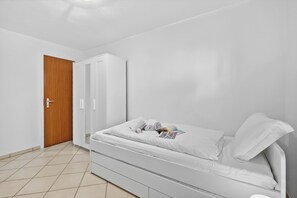 A bedroom with a bed, a wardrobe, and a door. - Panoramic Garden Lake View in Locarno Monti (Locarno)
