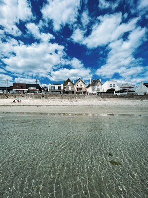 A beachfront property with a clear view of the ocean, a sandy beach, and a row of houses. - Ty Embruns (Larmor-Plage)