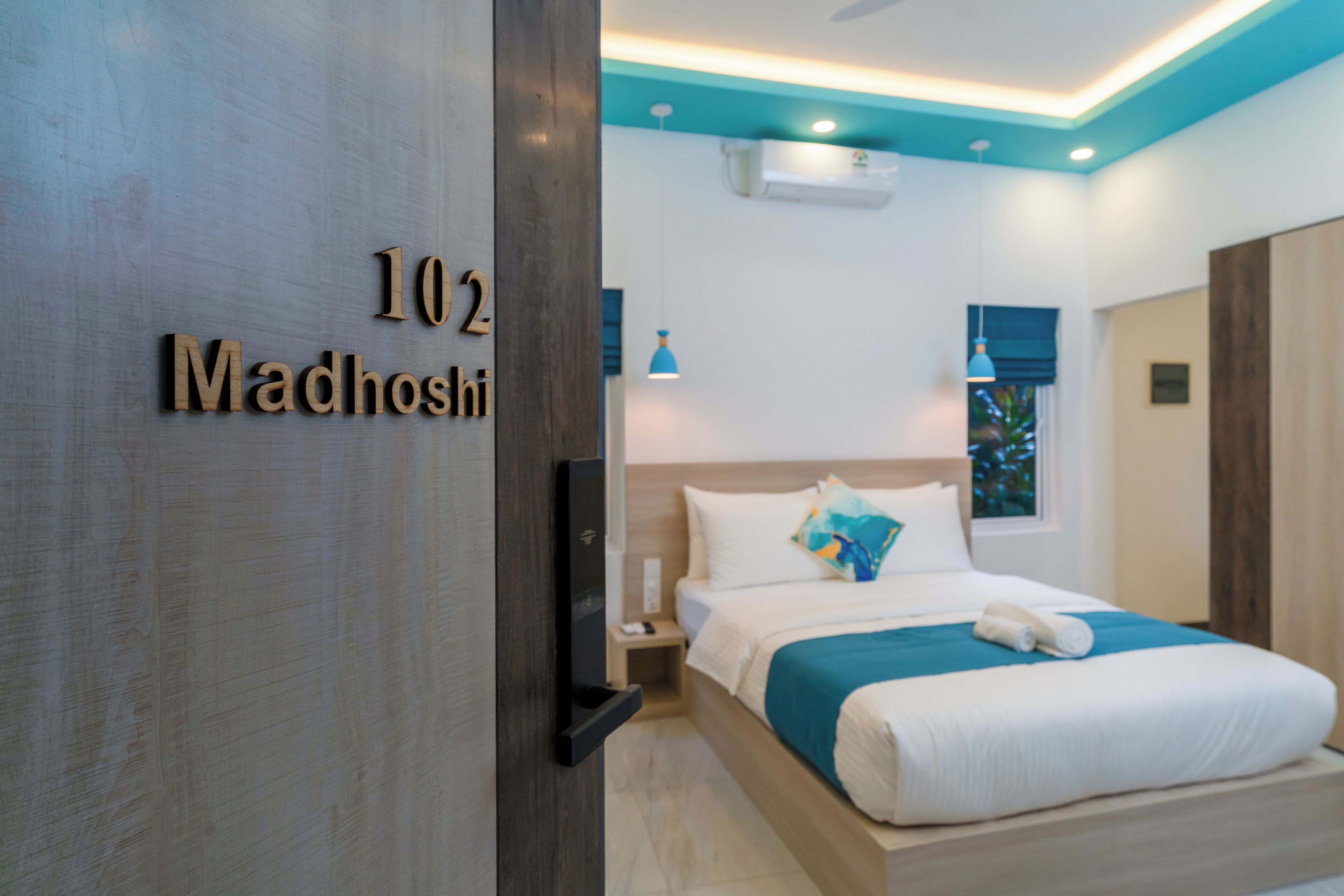 A hotel room with a bed, a nightstand, a TV, and a window with a view.