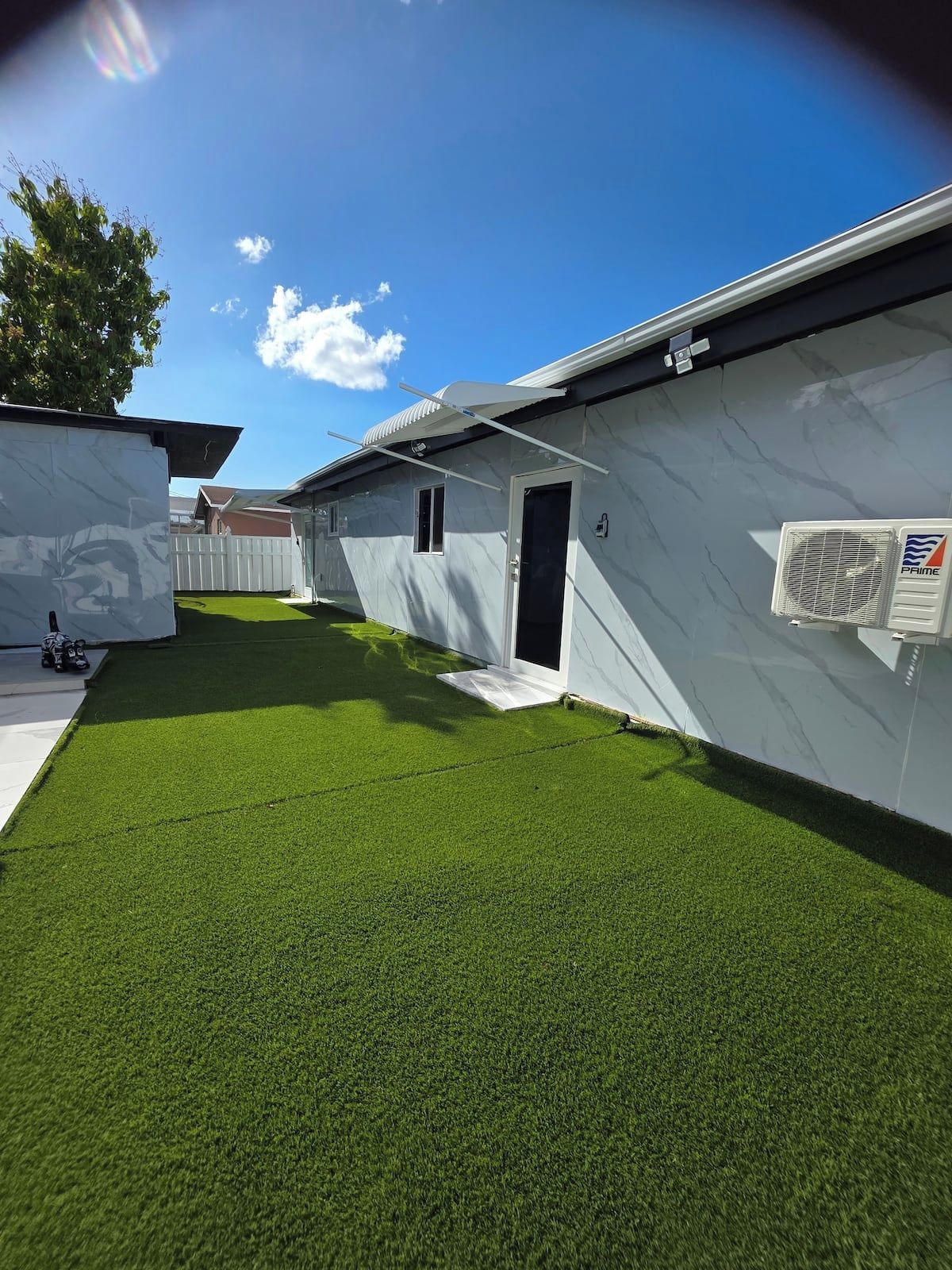 A modern building with a flat roof, a small door, and a window.